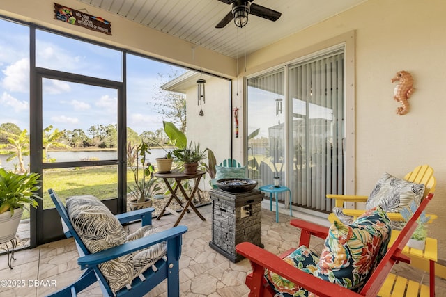 sunroom featuring a water view and ceiling fan