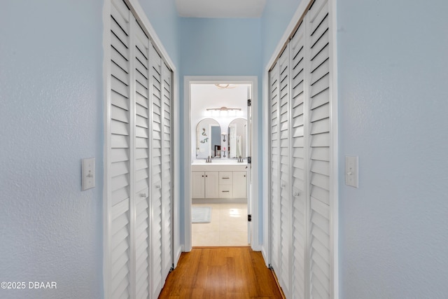 hall with sink and light hardwood / wood-style floors