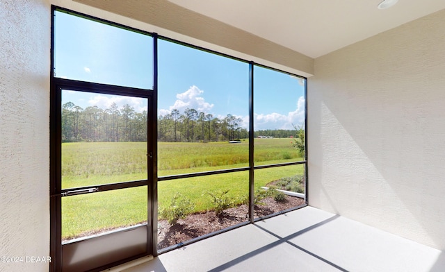 unfurnished sunroom featuring a rural view