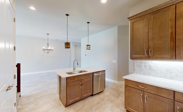 kitchen with backsplash, pendant lighting, sink, stainless steel dishwasher, and a kitchen island with sink