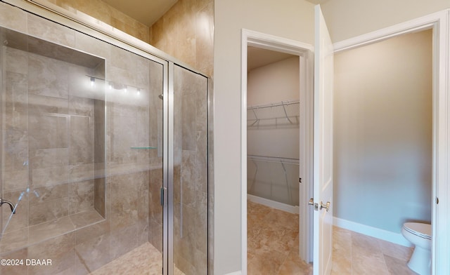 bathroom with walk in shower, tile patterned flooring, and toilet