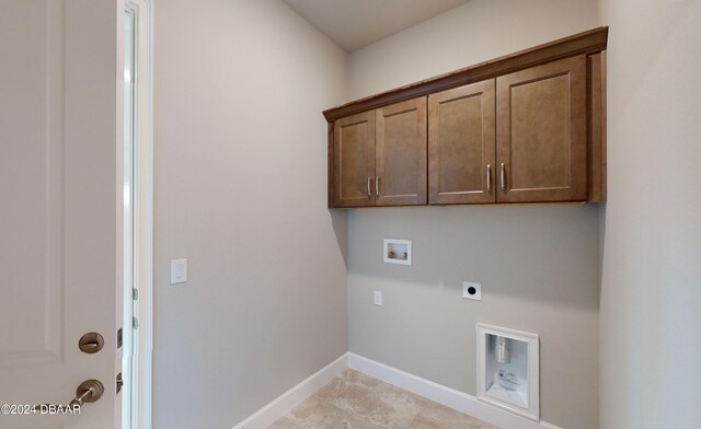 washroom featuring washer hookup, electric dryer hookup, light tile patterned flooring, and cabinets