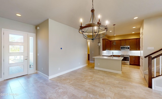 kitchen featuring an inviting chandelier, sink, an island with sink, pendant lighting, and appliances with stainless steel finishes