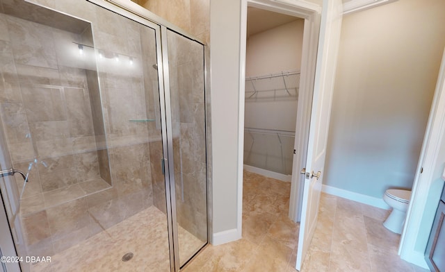 bathroom featuring tile patterned floors, toilet, and a shower with shower door