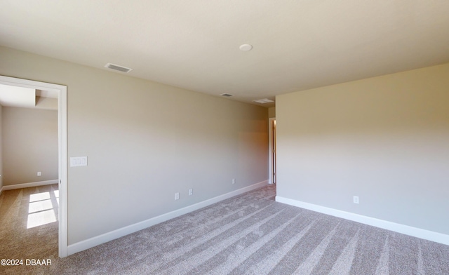 unfurnished room featuring light carpet