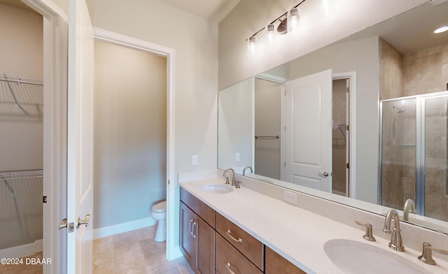 bathroom with vanity, tile patterned floors, toilet, and a shower with shower door