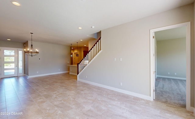 carpeted empty room with a notable chandelier