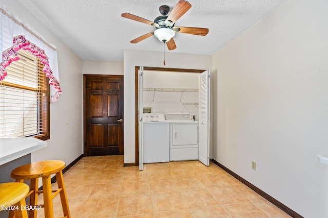 laundry area with light tile patterned floors, a textured ceiling, separate washer and dryer, and ceiling fan