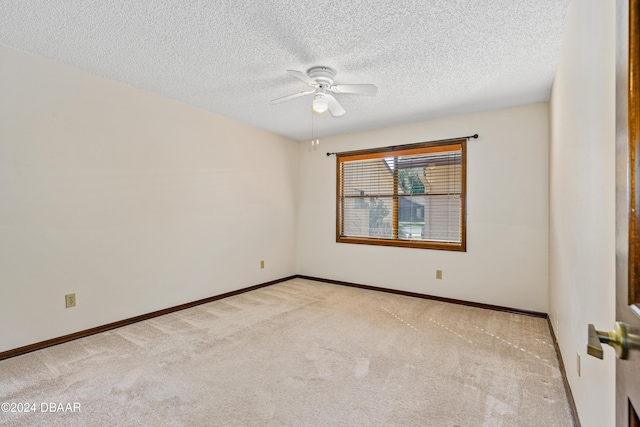 carpeted empty room featuring ceiling fan and a textured ceiling