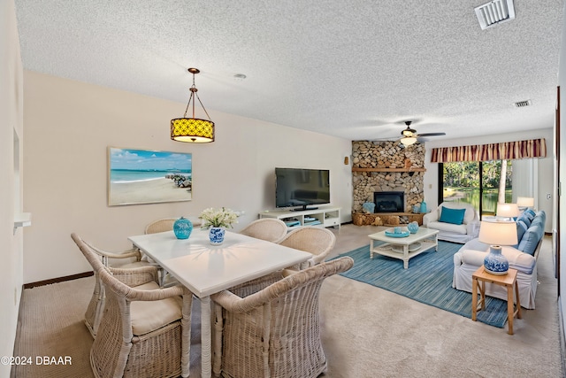 carpeted dining area featuring a fireplace, a textured ceiling, and ceiling fan