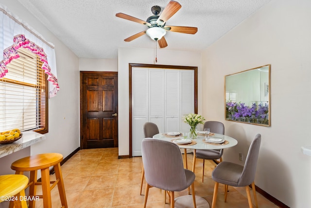 dining room with ceiling fan, light tile patterned floors, and a textured ceiling