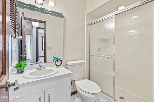 bathroom with tile patterned flooring, vanity, toilet, and a shower with door