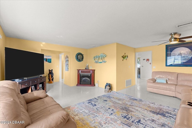 living room featuring ceiling fan and a textured ceiling