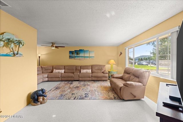 living room with a textured ceiling and ceiling fan