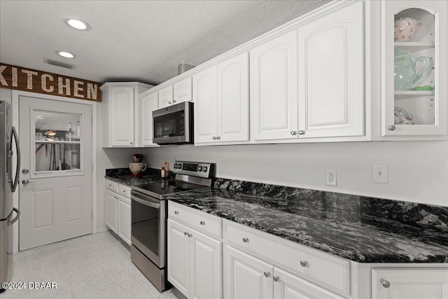 kitchen featuring white cabinets, appliances with stainless steel finishes, and a textured ceiling