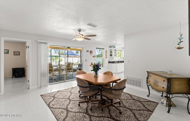 dining area featuring a textured ceiling and ceiling fan