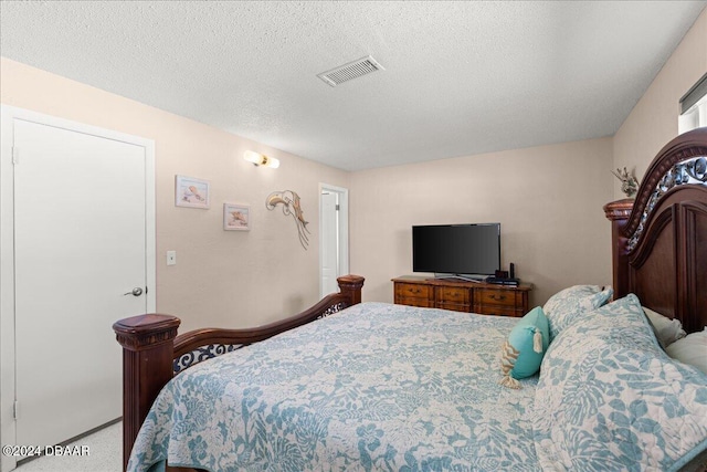 bedroom with carpet and a textured ceiling