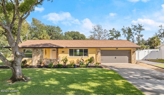 ranch-style home featuring a garage and a front lawn