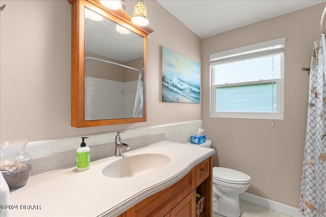 bathroom featuring vanity, toilet, and a shower with shower curtain