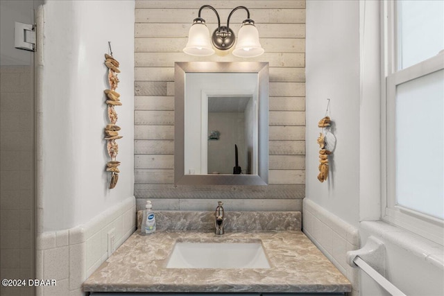 bathroom featuring vanity and wooden walls