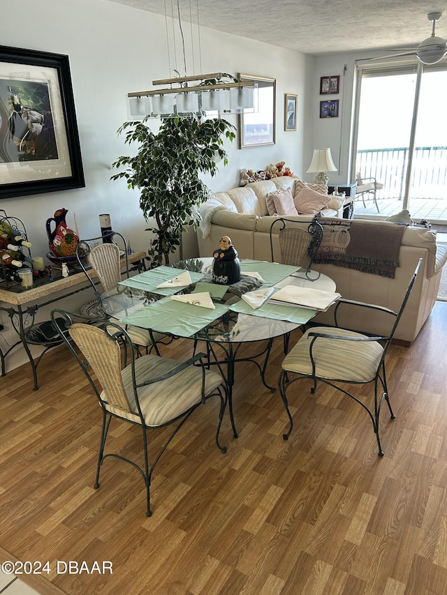 dining area with hardwood / wood-style floors and a textured ceiling