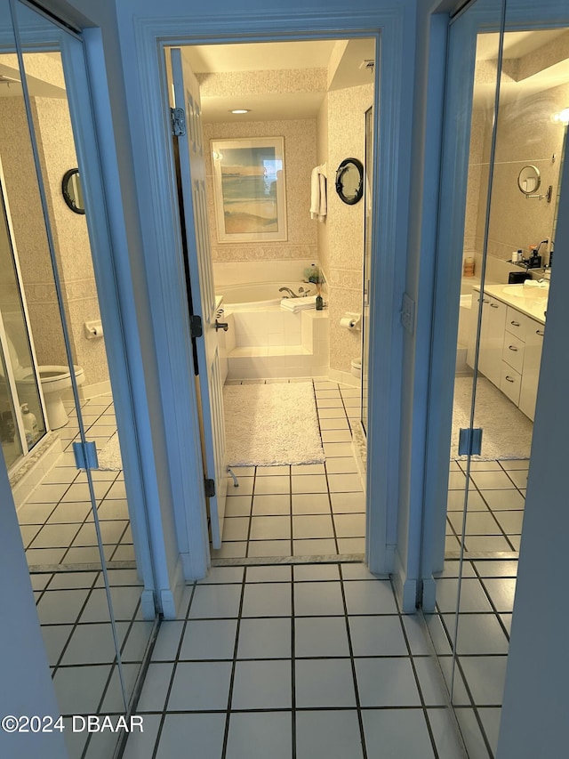 bathroom featuring tile patterned floors, a tub to relax in, vanity, and a textured ceiling