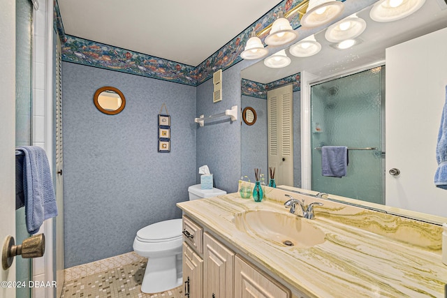 bathroom featuring tile patterned floors, vanity, toilet, and a shower with shower door