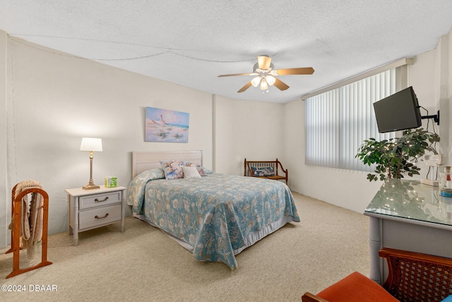 bedroom featuring a textured ceiling, light colored carpet, and ceiling fan