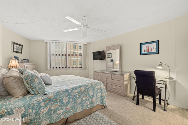 bedroom with ceiling fan, light colored carpet, and a textured ceiling