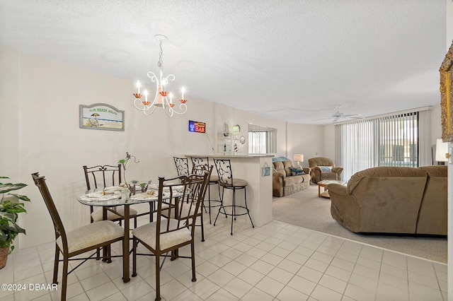 dining space with a textured ceiling, light carpet, and ceiling fan with notable chandelier