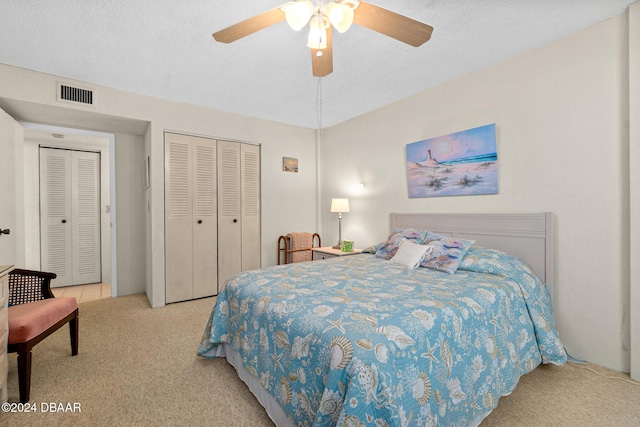 bedroom featuring ceiling fan, light carpet, and a textured ceiling