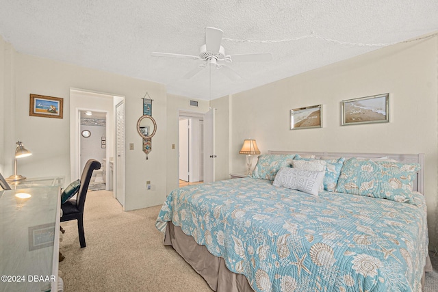 carpeted bedroom featuring ceiling fan and a textured ceiling