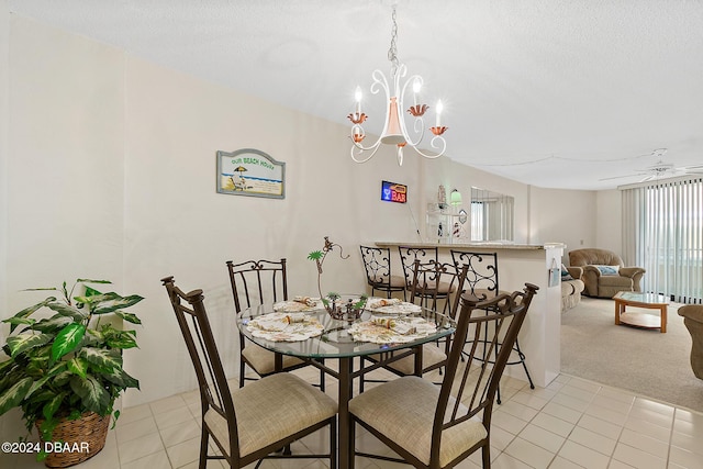 carpeted dining area featuring ceiling fan with notable chandelier and a textured ceiling