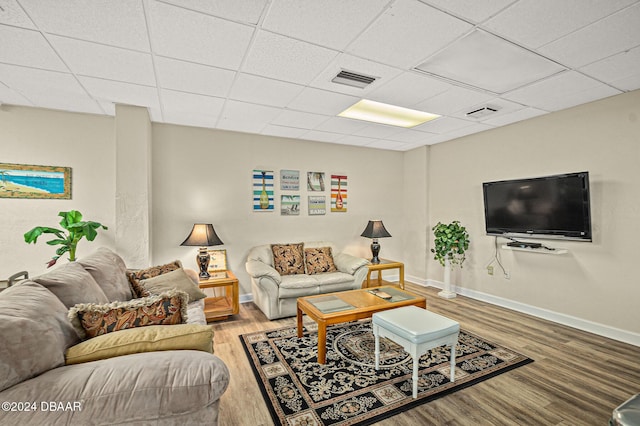 living room with wood-type flooring and a paneled ceiling