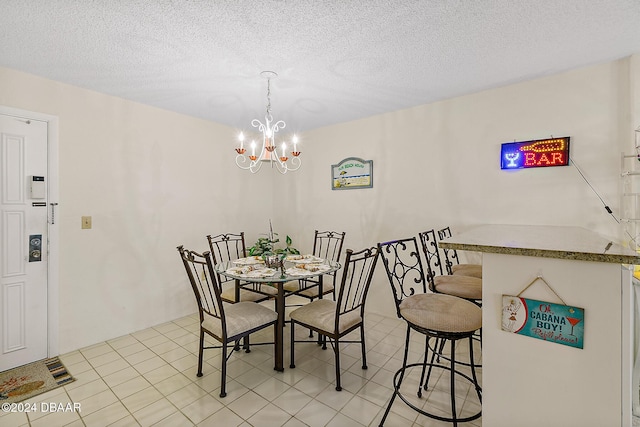 dining room featuring light tile patterned floors, a textured ceiling, and a notable chandelier