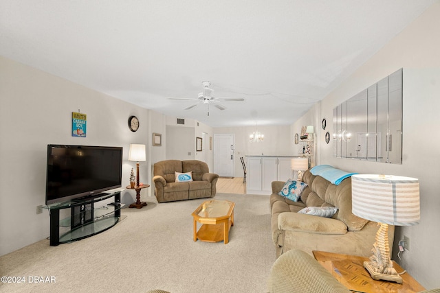 living room with ceiling fan with notable chandelier and light colored carpet