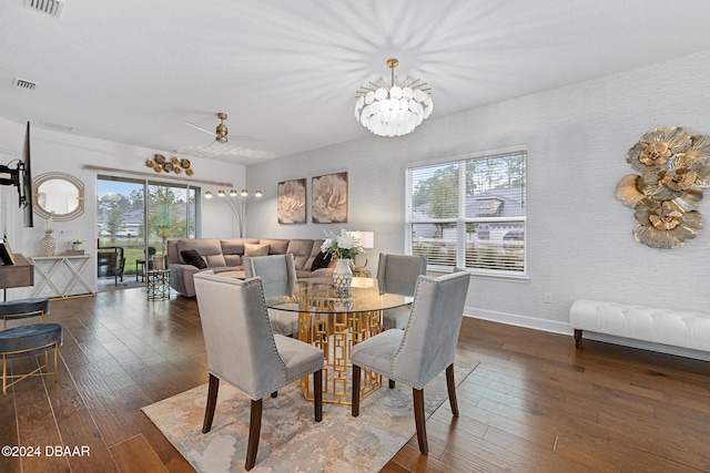 dining area with dark wood-type flooring and ceiling fan with notable chandelier