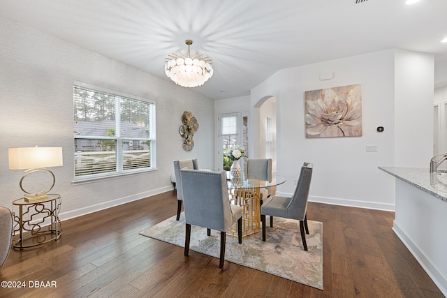 dining room featuring dark hardwood / wood-style flooring, a wealth of natural light, and a notable chandelier