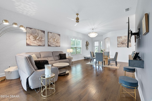 living room featuring ceiling fan with notable chandelier and dark hardwood / wood-style flooring