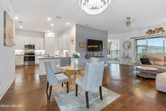 dining area with dark hardwood / wood-style flooring and ceiling fan with notable chandelier