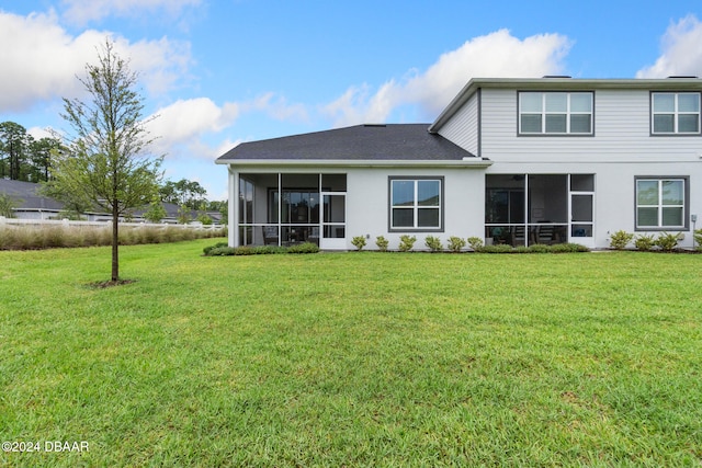 back of house featuring a sunroom and a lawn