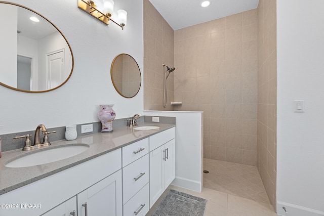 bathroom with tile patterned floors, vanity, and tiled shower