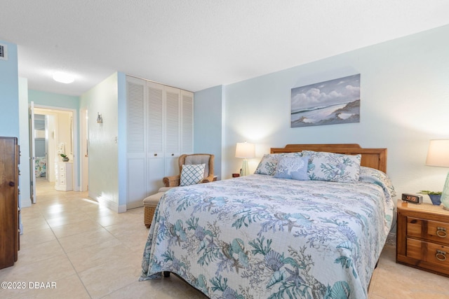 bedroom featuring a closet, a textured ceiling, and light tile patterned flooring