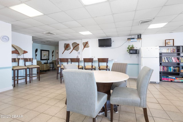 dining room with a paneled ceiling and light tile patterned floors