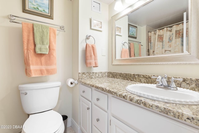 bathroom featuring toilet, vanity, and curtained shower