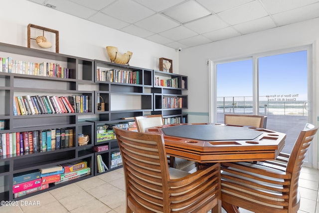 interior space with a drop ceiling and tile patterned flooring