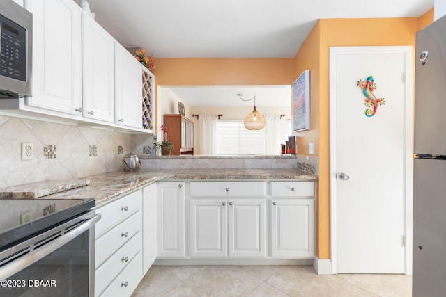 kitchen with stainless steel appliances, light stone counters, decorative backsplash, light tile patterned floors, and white cabinetry