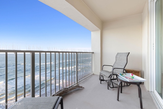 balcony featuring a view of the beach and a water view