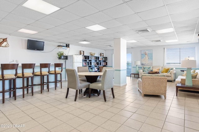 tiled dining space with a paneled ceiling