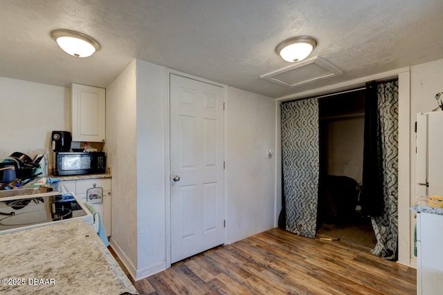 421 N Peninsula Dr, Daytona Beach, FL 32118 - corridor featuring attic access, wood finished floors, and a textured ceiling